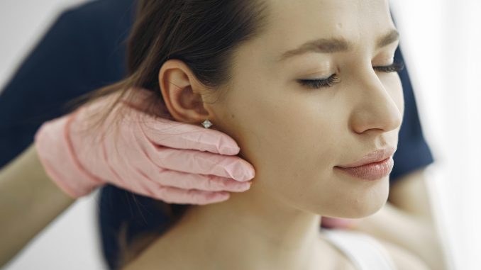 cosmetic surgeon gently touching a patient's jawline, seemingly assessing her for a facelift procedure