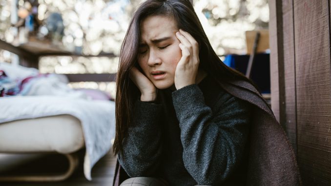 woman sitting and wincing in pain