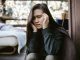 woman sitting and wincing in pain