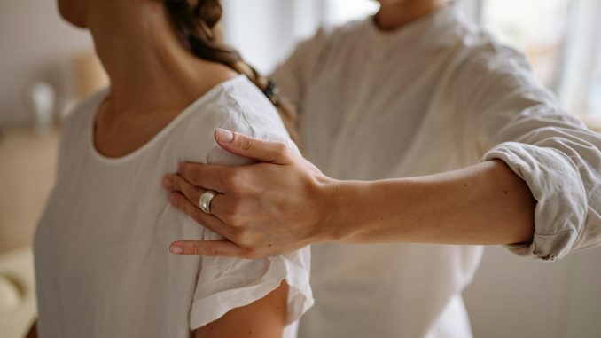 medical practitioner applying pressure to a patient's arm